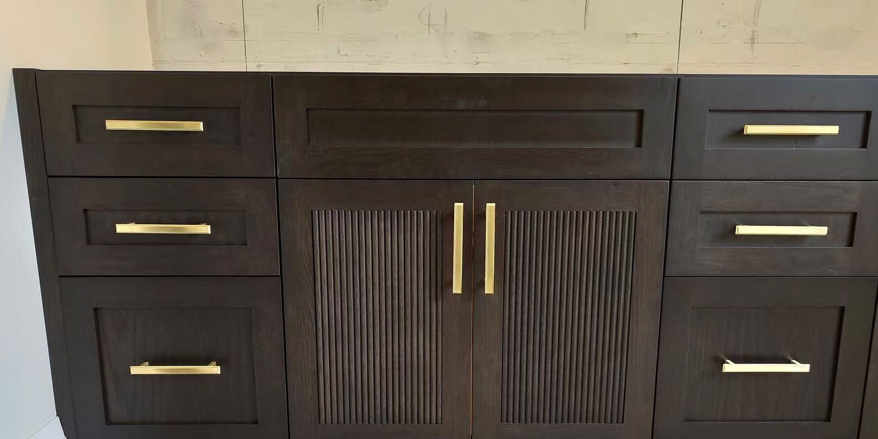 Dark wood modern vanity with reeded cabinet doors and brass hardware